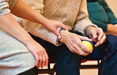 Carer holding pensioners hand